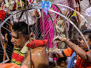 Photograph of a man who carried the kavadi up the hill having its skewers removed in Batu Caves at Thaipusam festival, photo by Ivan Kralj