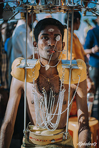 Photo of Prakash J Govindarajoo, a pilgrim at Thaipusam 2017, with his mouth and tongue pierced, carrying a kavadi, photo by Alphabeatz Production