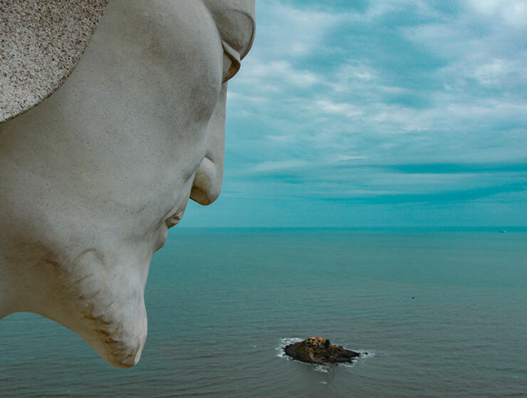 The head of Christ the King statue in Vung Tau, Vietnam, overlooking the South China Sea, with a little island, and dark clouds in the sky, photo by Ivan Kralj