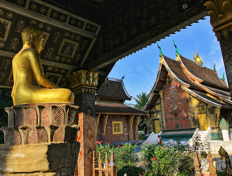Buddha statue next to the sim of the Wat Xieng Thong, a Buddhist