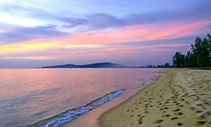 Sandy Ong Lang Beach at Phu Quoc Island in Vietnam, during sunset that coloured its skys orange, yellow, and different shades of purple and pink; photo by Ivan Kralj.