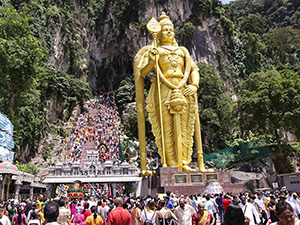 Photo of pilgrims gathering and climbing to Batu Caves, passing by the golden statue of Lord Murugan at the base of the hill, photo by Ivan Kralj