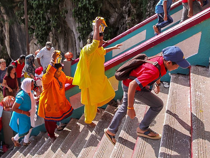 Photograph of pilgrims climbing the stairs of Batu Caves and carrying Paal Kudam, brass pots filled with milk, as offerings for Thaipusam festival, photo by Ivan Kralj
