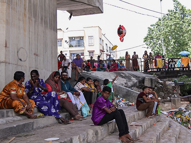 Photograph of Thaipusam pilgrims resting in the shade at the river bank at Thaipusam festival