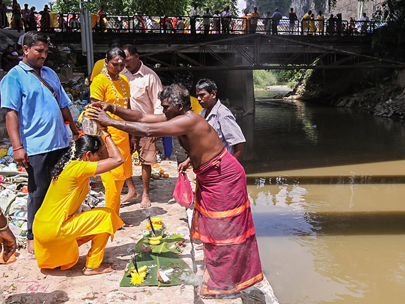 Photograph of the family father putting the Paal Kudam at his family member's head after the ritual at the river at Thaipusam, photo by Ivan Kralj