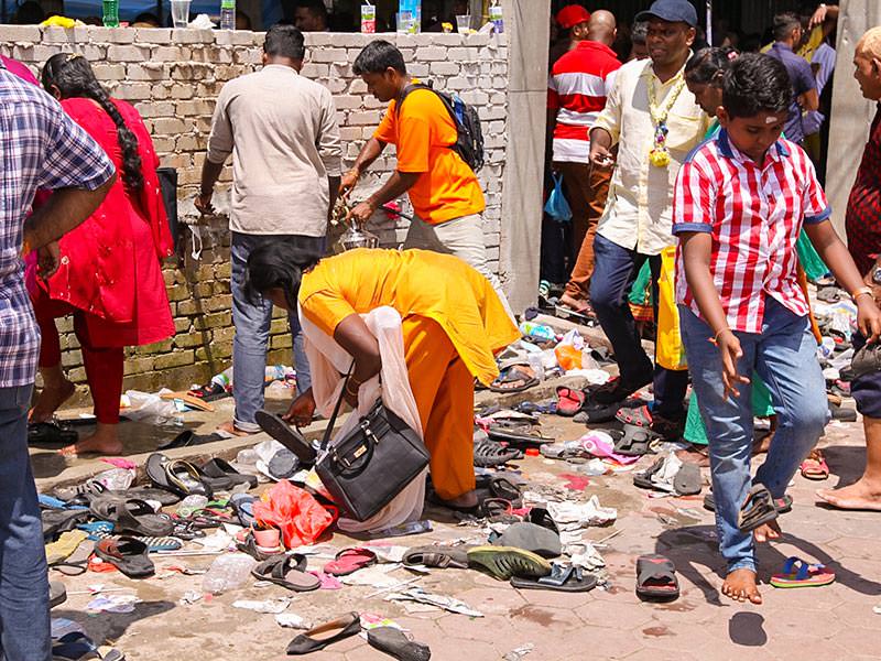 Photograph of a woman searching for her shoes at the entrance of one of the temples at Batu Caves - with million and half of visitors at Thaipusam shoes get easily lost, photo by Ivan Kralj