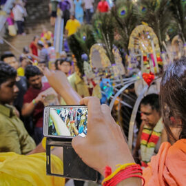 Photograph of tourists photographing the Kavadi bearer removing his skewers and piercings, photo by Ivan Kralj