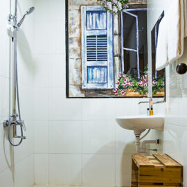 Photo of the bathroom in The Laban hotel, with shower, sink, wooden box, painting of the window on the wall, photo by Ivan Kralj