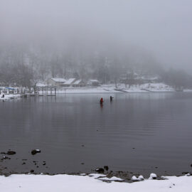 Two fishermen standing waist-deep in the snow-surrounded Chuzenji Lake, close to Nikko, Japan, photo by Ivan Kralj