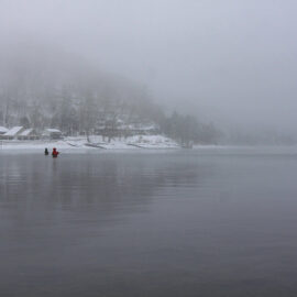 Two fishermen standing waist-deep in the snow-surrounded Chuzenji Lake, close to Nikko, Japan, photo by Ivan Kralj