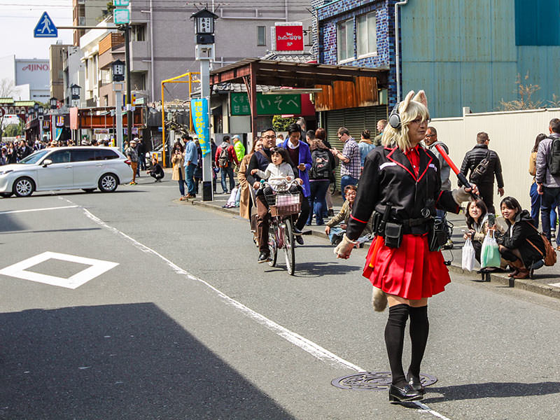 Crossdresser is walking down the street and clearing it up from people for the penis parade at Kanamara Matsuru, festival of the iron penis, in Kawasaki, Japan, photo by Ivan Kralj