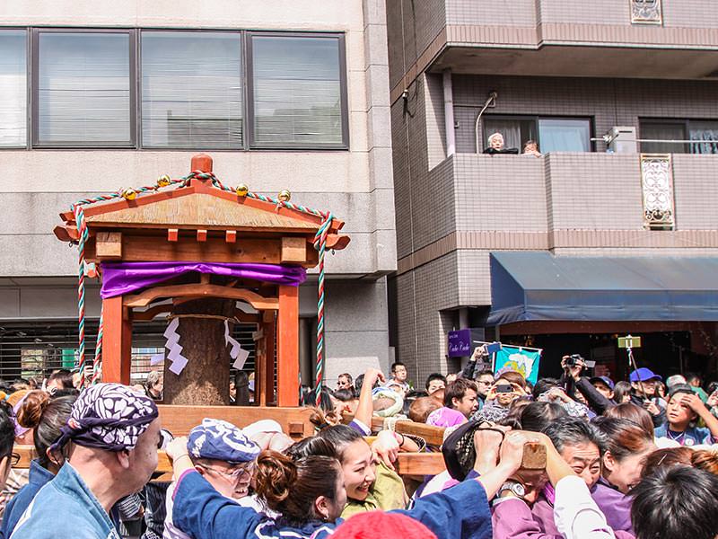 Wooden penis-shaped mikoshi, portable shrine, being carried in the street at Kanamara Matsuru, festival of the iron penis, in Kawasaki, Japan, photo by Ivan Kralj