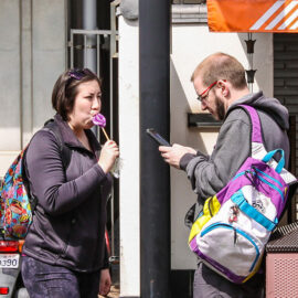 A woman licking the vagina shaped lollipop, while her partner is texting on mobile phone at Kanamara Matsuru, festival of the iron penis, in Kawasaki, Japan, photo by Ivan Kralj