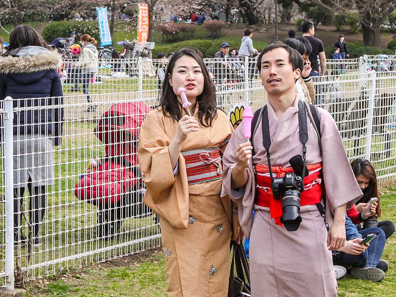 A couple in kimonos posing with penis shaped lollipops at Kanamara Matsuru, festival of the iron penis, in Kawasaki, Japan, photo by Ivan Kralj