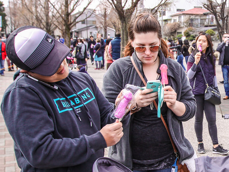 Women unwrapping the penis shaped lollipops at Kanamara Matsuru, festival of the iron penis, in Kawasaki, Japan, photo by Ivan Kralj