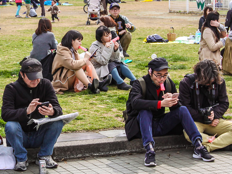 People licking penis-shaped lollipops in the park in Kawasaki, Japan, during the Kanamara Matsuri, festival of the iron penis, photo by Ivan Kralj