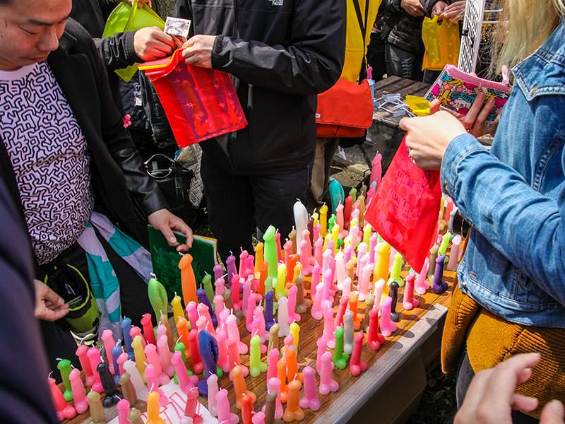 A man selling colorful candles in the shape of penis and vagina, at Kanamara Matsuru, festival of the iron penis, in Kawasaki, Japan, photo by Ivan Kralj