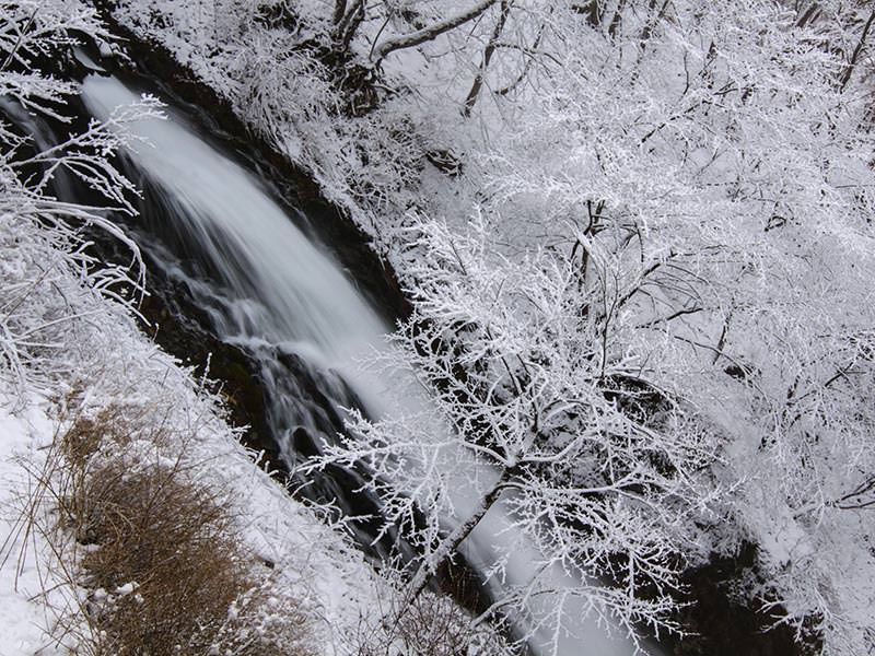 Kegon Falls' water making its way through the snowy surrounding, birds eye perspective, Japan, photo by Ivan Kralj