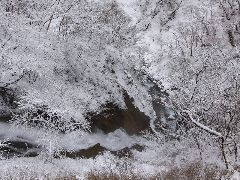 Kegon Falls' water making its way through the snowy surrounding, birds eye perspective, Japan, photo by Ivan Kralj