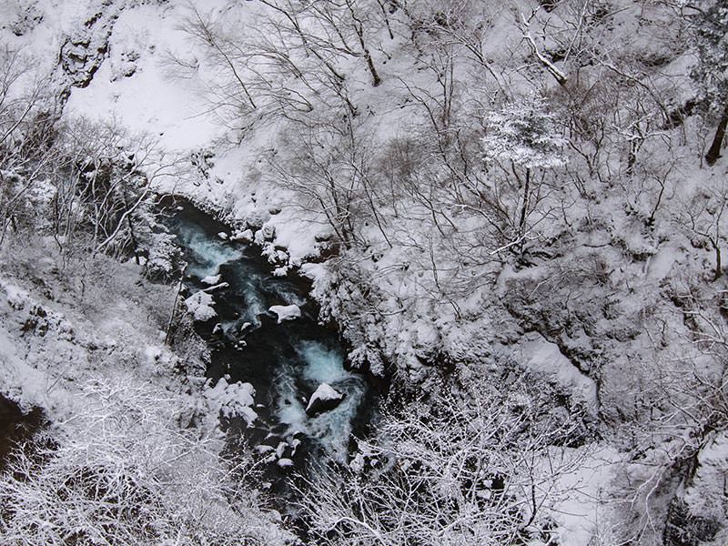 Kegon Falls' water making its way through the snowy surrounding, birds eye perspective, Japan, photo by Ivan Kralj