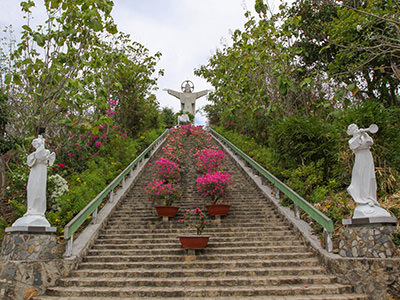 Flowers and sculpture-adorned stairs leading to Christ of Vung Tau statue in Vietnam, photo by Ivan Kralj