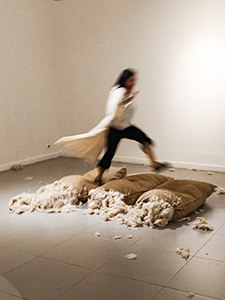 The girl visitor of Galeri National Indonesia in Jakarta, running over the jute sacks, while carrying the dress on a hanger in hands, all elements of Ratu R. Saraswati's artwork "I Beg I Promise". This shocking intervention in the art installation is explained by the girl's intention to be photographed for social media, at the EXI(S)T - Tomorrow As We Know It exhibition, photo by Ivan Kralj