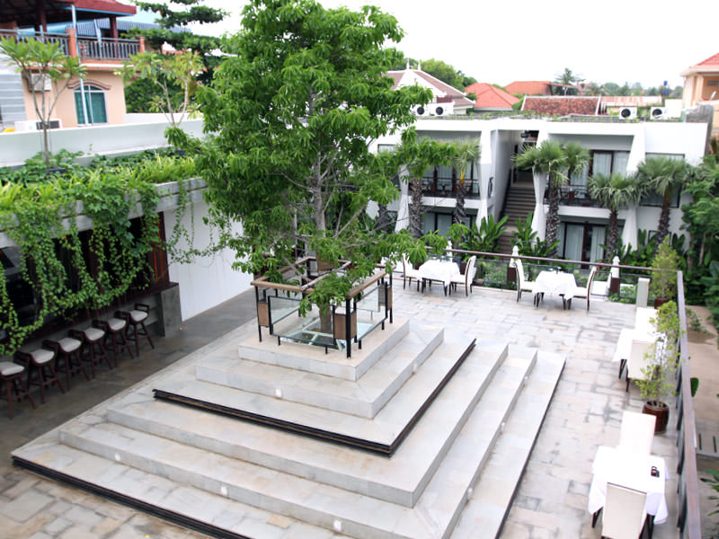 Jaya House River Park hotel terrace, with a tree protruding the roof from the restaurant below, in Siem Reap, Cambodia, photo by Ivan Kralj