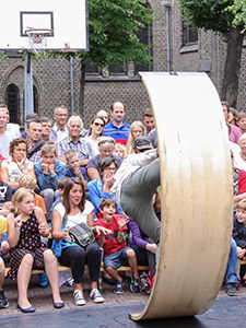 French acrobat Jonathan Guichard (Cie H.M.G.) performs his performance "3D" by balancing on the apparatus in the close proximity of the audience - the expression of shock and surprise could be read from the faces of the woman and children seated in the first row, just in front of the artist, at Miramiro street theatre festival, in Ghent, Belgium, photo by Ivan Kralj