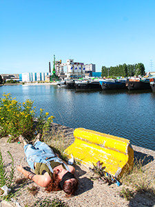 Blindfolded audience member lies on ground in the port of Ghent, at the end of Kamchatka's performance "Fugit", at Miramiro festival in Ghent, Belgium, photo by Ivan Kralj