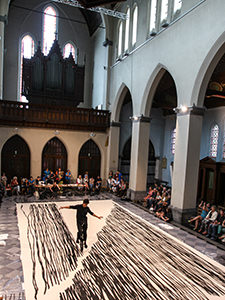 Unicycle rider Kenzo Tokuoka performs his "Sho-Ichido" performance in which he paints a large piece of canvas with black traces of unicycle tyre dipped in paint, in a church in Ghent, Belgium, at Miramiro festival, photo by Ivan Kralj