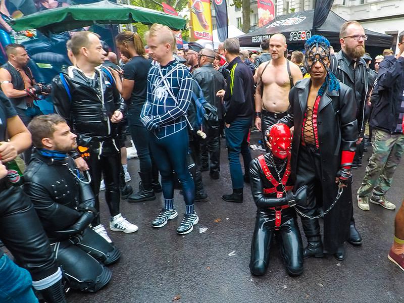 Leather man with a mask-covered slave on a leash at Folsom Europe Street Fair, the biggest European gay fetish event, in Berlin, Germany, photo by Ivan Kralj