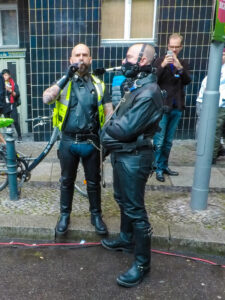 A man smoking a cigar and the slave holding an ashtray with his mouth at Folsom Europe Street Fair, the biggest European gay fetish event, in Berlin, Germany, photo by Ivan Kralj