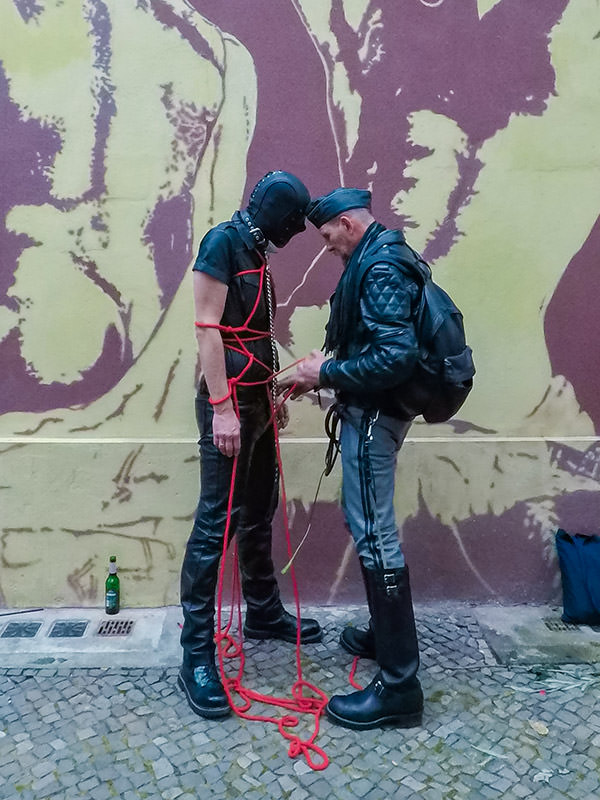 Master is tying his mask-covered slave with shibari style ropes at Folsom Europe Street Fair, the biggest European gay fetish event, in Berlin, Germany, photo by Ivan Kralj