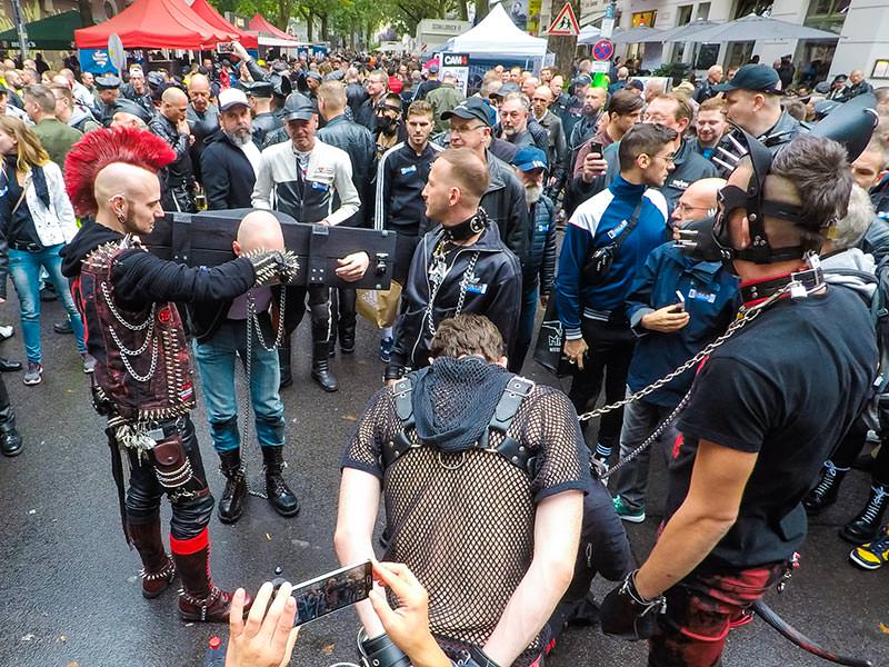 Punker locking the skinhead in wooden punishment stocks at Folsom Europe Street Fair, the biggest European gay fetish event, in Berlin, Germany, photo by Ivan Kralj