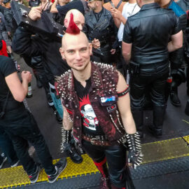 Punker leading the skinhead locked in wooden punishment stocks at Folsom Europe Street Fair, the biggest European gay fetish event, in Berlin, Germany, photo by Ivan Kralj