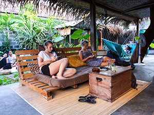 Guests resting on the sofas and hammocks on the terrace of Sae Sae, one of the best hostels of Java, in Yogyakarta, Indonesia, photo by Ivan Kralj