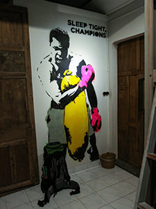 Mural of boxer Mohammad Ali with a text saying "Sleep tight, champions" in the dorm of Sae Sae, one of the best hostels of Java, in Yogyakarta, Indonesia, photo by Ivan Kralj.