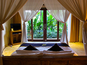 Bed with a view of a green terrace in Sankara Ubud Resort, one of the answers to where to stay in Bali, Indonesia, photo by Ivan Kralj