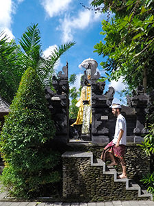 Blogger Ivan Kralj in traditional Balinese costume climbing to the little shrine in front of Sankara Ubud Resort, one of the answers to where to stay in Bali, Indonesia, photo by Ivan Kralj