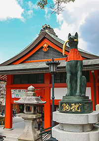 Fox statue with red napkin in front of the Fushimi Inari Taisha temple in Kyoto, Japan, photo by Ivan Kralj