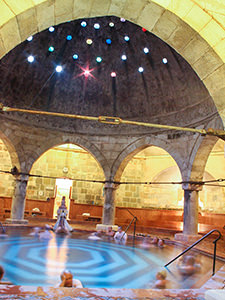 Octagonal pool in the main hall of Rudas Baths, covered with a hemispheric dome with colorful little glass windows