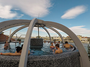 Visitors of Rudas Baths soaking in the open-air rooftop pool, with a view of Danube River, in Budapest, Hungary, photo by Ivan Kralj