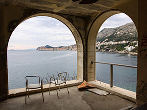 Two chairs on a terrace in the abandoned Hotel Belvedere Dubrovnik, Croatia, with a view of the seaside and the Old Town, photo by Ivan Kralj