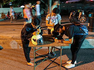 Young men writing on oranges for Chap Goh Mei, Chinese Valentine's Day tradition
