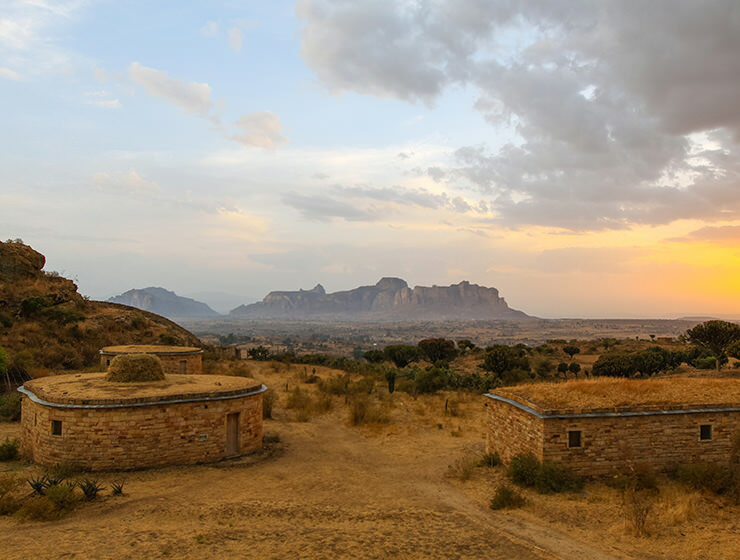 Bungalows of Gheralta Lodge at sunset, with a view of misty Gheralta Mountains in distance, Tigray Region, Ethiopia, photo by Ivan Kralj