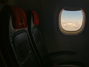 Empty seats in the plane with clouds viewable through the window - jet lag might be affecting travel fogginess, photo by Ivan Kralj