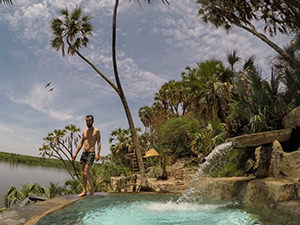 Pipeaway blogger Ivan Kralj walking on the edge of the pool filled with hot spring water, above the Doho Lake encircled by palm trees, at Doho Lodge, one of Ethiopian wildlife lodges, photo by Ivan Kralj.