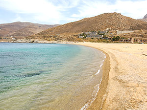 The sandy Vagia Beach on Serifos island, with Coco-Mat Eco Residences in the background, one of the best beachfront hotels in Cyclades Islands