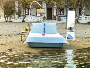 Bed set for sleeping placed on the Achladi Beach in Syros, in front of the Hotel Emily, one of the best beachfront hotels in Cyclades Islands, Greece