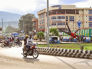 Acrobat from Arba Minch Circus performing a 'human flag' figure on the traffic sign at the roundabout in Arba Minch, Ethiopia, while the motorbikes and bajajs participate in traffic, photo by Ivan Kralj